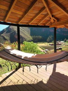 a hammock on a deck with a view of a mountain at Wolf Totem Steam Punk Loft Villa in Pisac