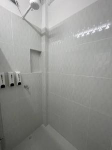 een badkamer met een douche en witte tegelmuren bij Apartamento Completo 601 in Medellín