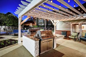 an outdoor kitchen with a grill and a pergola at Homewood Suites by Hilton Atlanta-Galleria/Cumberland in Atlanta