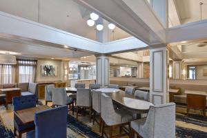 ウィンザー・ロックスにあるHomewood Suites by Hilton Windsor Locks Hartfordの建物内のテーブルと椅子のあるレストラン