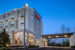 a hotel with a sign on the front of it at Hampton Inn & Suites Seattle/Federal Way in Federal Way