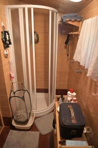 にあるOstoja dom letniskowyの小さなバスルーム(シャワー、スーツケース付)