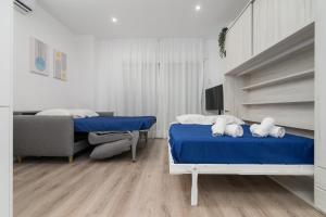 a bedroom with two beds and a couch in it at Suite Homes Hesperides garden beach in Málaga
