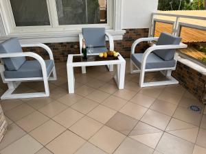 Duas cadeiras e uma mesa num pátio em Appartement Altona em Lomé