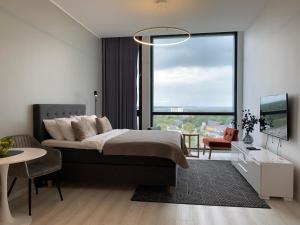 a bedroom with a bed and a large window at Orange Apartments Tower & Free Parking in Tallinn