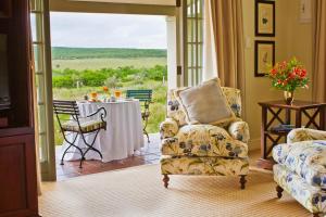 a living room with a table and a chair at River Bend Lodge in Addo