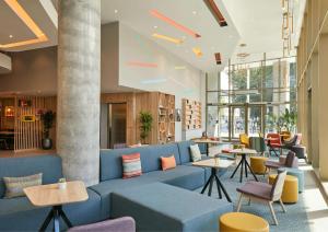 a lobby with a blue couch and tables and chairs at Hampton By Hilton Dublin City Centre in Dublin