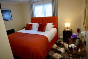 a bedroom with a red bed and a window at Tu Guesthouse in Stanley