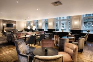 a restaurant with tables and chairs and a bar at Hilton Edinburgh Carlton in Edinburgh