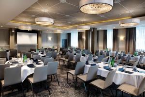 a conference room with tables and chairs and a screen at Hilton Edinburgh Carlton in Edinburgh