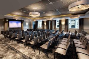 a conference room with chairs and a projection screen at Hilton Edinburgh Carlton in Edinburgh
