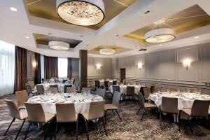 una sala de banquetes con mesas, sillas y luces en Hilton Edinburgh Carlton, en Edimburgo
