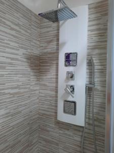een badkamer met een douche met een douchekop bij Holiday Home Dolia Center in Dolianova