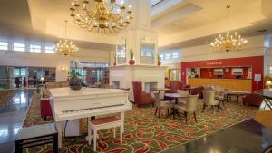 a lobby with a grand piano and tables and chairs at Hilton Leicester Hotel in Leicester