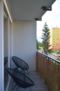 een patio met 2 stoelen en een tafel op een balkon bij Apartment Hemsen in Prešov