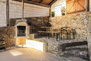 a stone building with a table and a stone oven at Refúgio das Carquejas in Mondim de Basto
