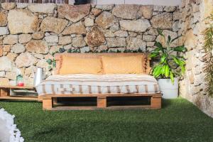 a bed in a room with a stone wall at Refúgio das Carquejas in Mondim de Basto +23 photos
