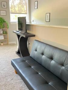Una sala de estar con un sofá y una mesa con una computadora portátil. en Studio Townhouse in Uptown King Bed-Wi-Fi-Full Kitchen- Washer & Dryer, en Charlotte