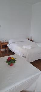 2 Betten mit Blumen auf einem Zimmer in der Unterkunft Villa Médicis Besançon in Besançon