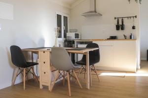 a kitchen with a wooden table and four chairs at Refúgio das Carquejas in Mondim de Basto