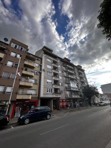 un'auto parcheggiata di fronte a un edificio in una strada di Apartman San a Ruma
