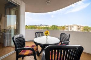 a balcony with a table and chairs and a window at Beach apartment Calafell center with parking in Calafell