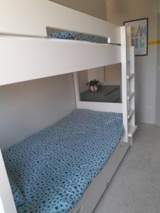 a bedroom with bunk beds with a blue bedspread at Felix De Haan in De Haan