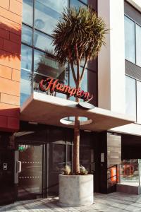 托基Hampton By Hilton Torquay的一座带标志的建筑前的棕榈树