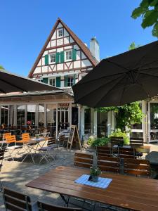 un patio extérieur avec des tables, des chaises et des parasols dans l'établissement Waldhotel Eichenhof, à Aalen