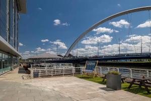 un puente sobre un río con una señal delante de él en Hilton Garden Inn Glasgow City Centre, en Glasgow