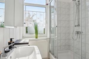a bathroom with a sink and a tub and a window at Schönes Ferien-Appartement für bis zu 6 Personen in Halberstadt +17 photos
