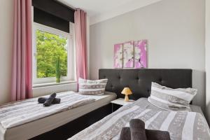 a bedroom with two beds and a window at Schönes Ferien-Appartement für bis zu 6 Personen in Halberstadt