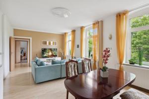 uma sala de estar com um sofá e uma mesa em Schönes Ferien-Appartement für bis zu 6 Personen em Halberstadt