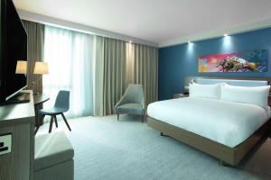 a hotel room with a bed and a television at Hampton By Hilton Hamilton Park in Hamilton