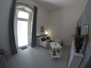 sala de estar con cama y ventana grande en Borgata di Levante, en Siracusa