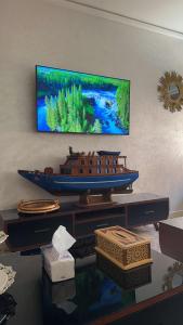 a shelf with a model of a boat on a wall at Appartement de Lux Hay Al MATAR in Nador