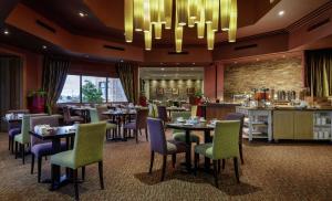 restauracja ze stołami i krzesłami oraz żyrandolem w obiekcie Doubletree By Hilton Glasgow Westerwood Spa & Golf Resort w mieście Cumbernauld