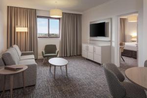 Cette chambre d'hôtel dispose d'un canapé et d'une télévision. dans l'établissement Doubletree By Hilton Glasgow Westerwood Spa & Golf Resort, à Cumbernauld