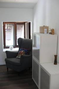 a living room with a chair and a window at Dimora Il Vecchio Mulino in Drena