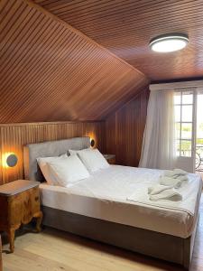 a bedroom with a large bed with a wooden ceiling at Gyra Villas - Villa Ermis with private pool in Lefkada +110 photos