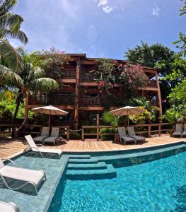 a resort with a swimming pool with chairs and umbrellas at Hotel Posada Seremein Roatan in West Bay