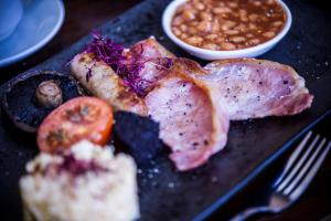 a plate of food with meat and a bowl of beans at DoubleTree by Hilton Cheltenham in Cheltenham