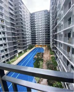 a view of a swimming pool between two apartment buildings at MOA Pasay, Shore 3 Residences - Modern Luxury Condo in Manila