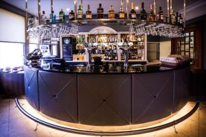 a bar with a lot of liquor bottles at DoubleTree by Hilton Cheltenham in Cheltenham
