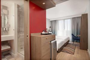 a hotel room with a bed and a bathroom at Hampton by Hilton High Wycombe in High Wycombe