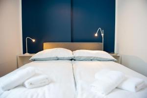 łóżko z białą pościelą i poduszkami w obiekcie Apartamenty Emilia w Gnieźnie