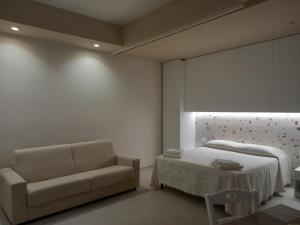 a bedroom with a bed and a couch and a window at Casa Vacanze Mariantò in Noci