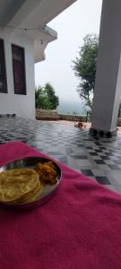 a plate of food on a table with a plate of chips at Kareri Wayfarer in Dharamshala