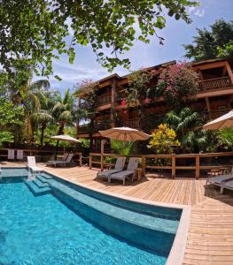 a resort with a pool and chairs and umbrellas at Hotel Posada Seremein Roatan in West Bay