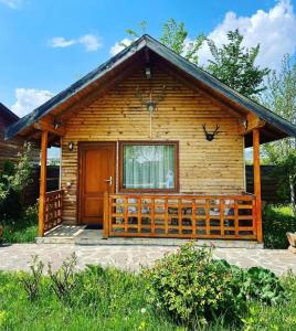 drewniany domek z dużymi drewnianymi drzwiami w obiekcie Sunset By The Farm w mieście Piatra Neamţ